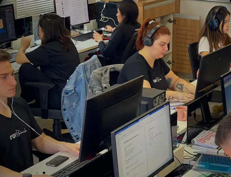 Profissionais da ROI Digital trabalhando concentrados em seus computadores no escritório