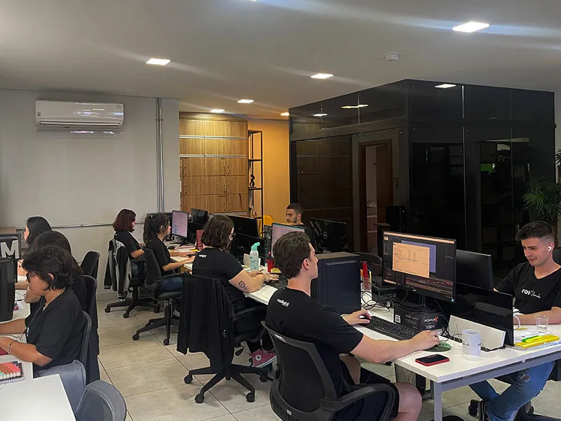 Escritório da ROI Digital em atividade, com profissionais trabalhando em suas mesas